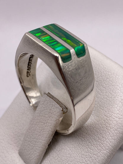 Anillo en mano de hombre mostrando el juego de colores verde y amarillo del ópalo
