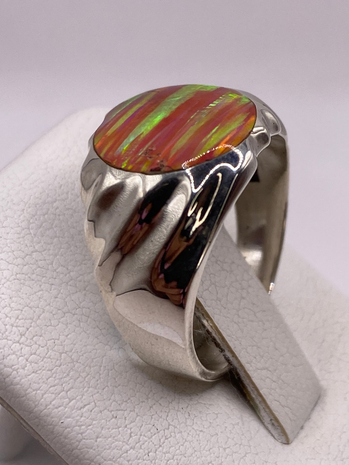 Detalle lateral del anillo mostrando los pliegues escultóricos y el engaste de ópalo