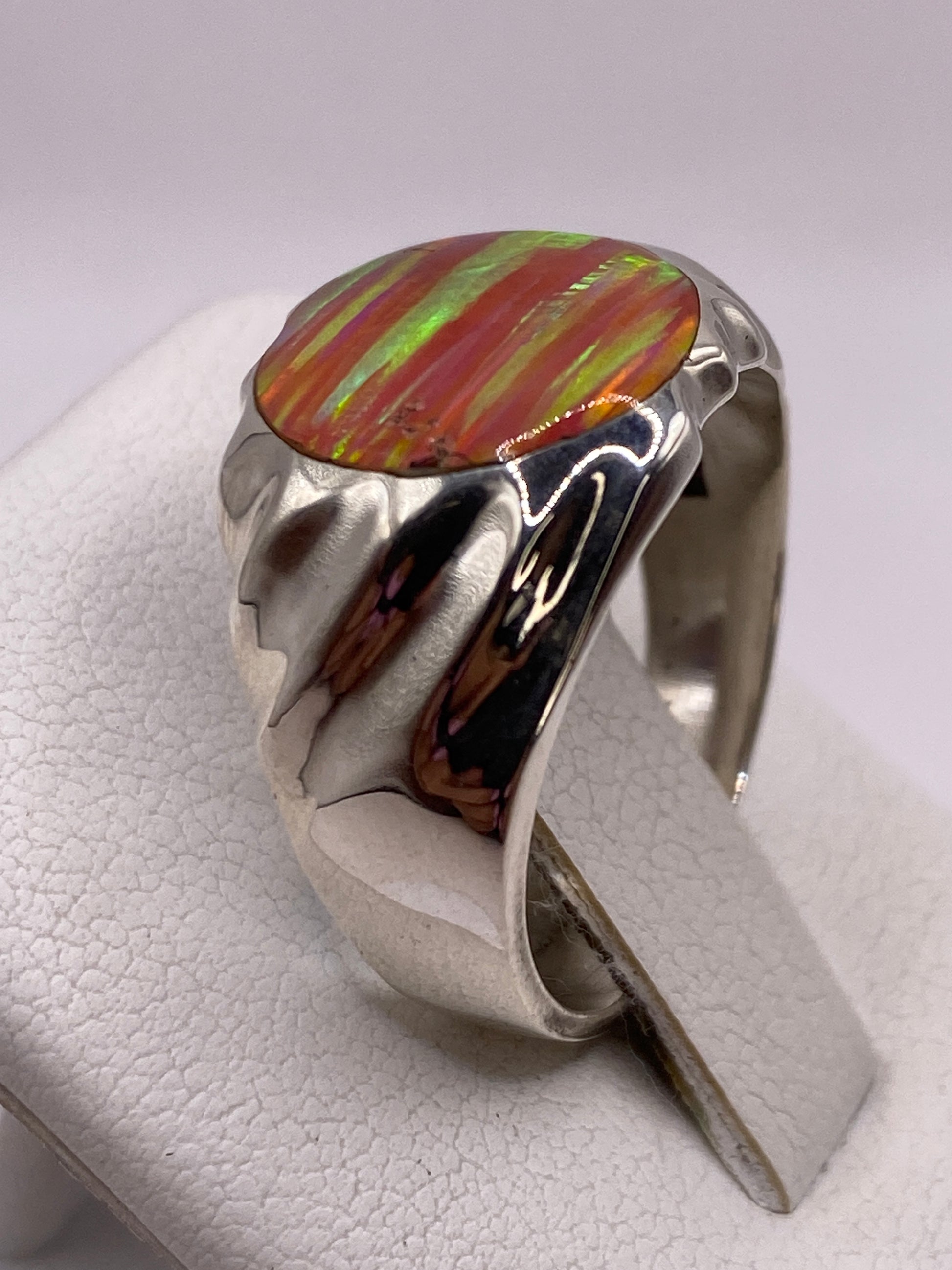 Detalle lateral del anillo mostrando los pliegues escultóricos y el engaste de ópalo