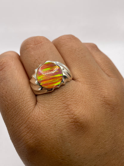 Anillo de ópalo de fuego puesto en dedo, exhibiendo el brillo y juego de colores natural de la piedra