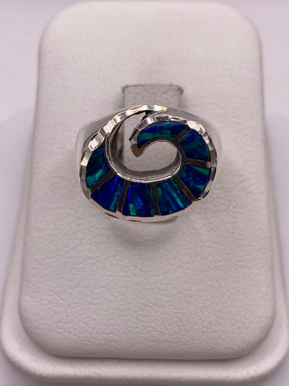 Anillo abanico de plata con ópalo de fuego azul intenso, vista frontal en estuche blanco