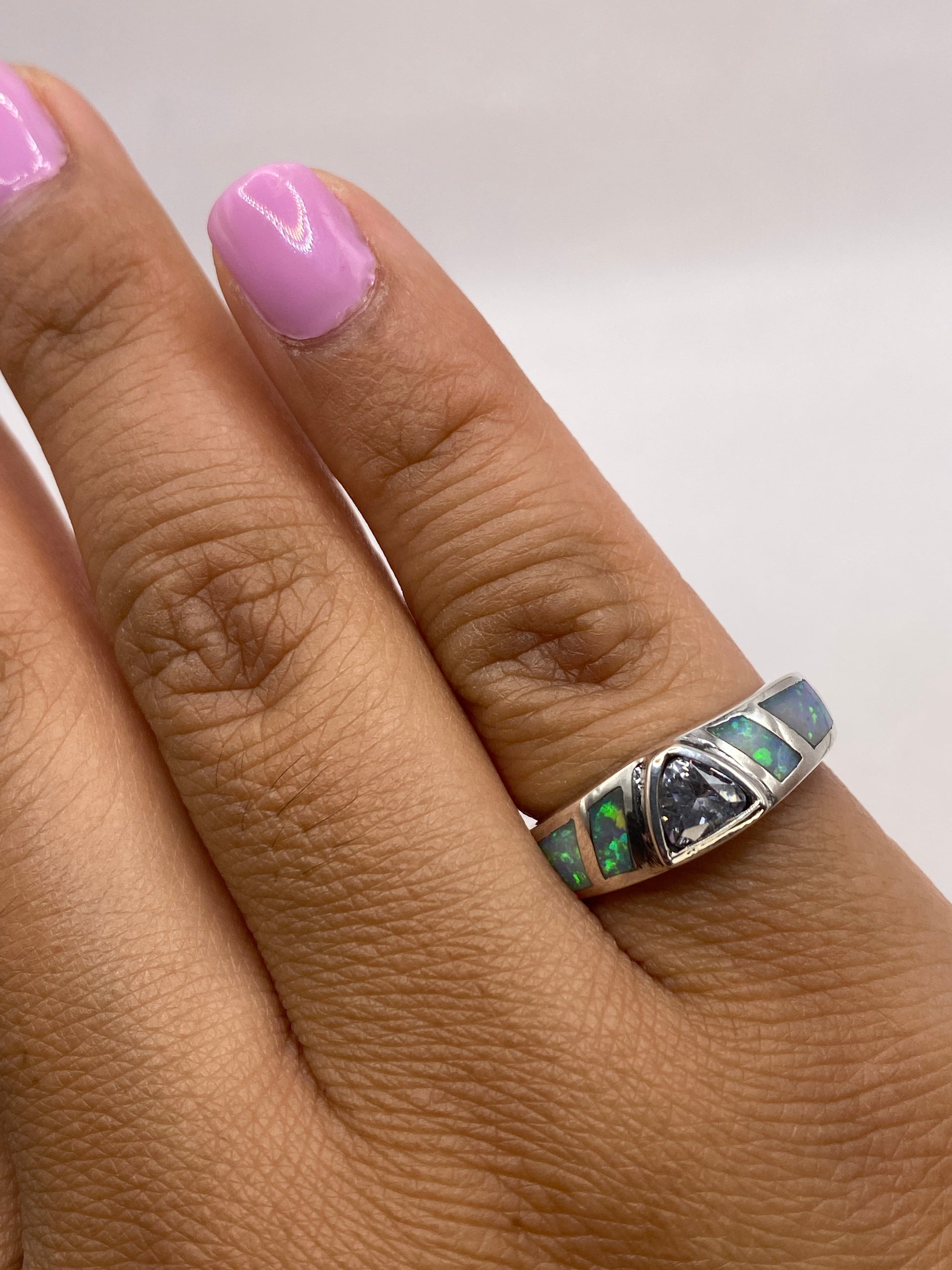 Anillo sobre la mano luciendo los tonos cambiantes del ópalo natural