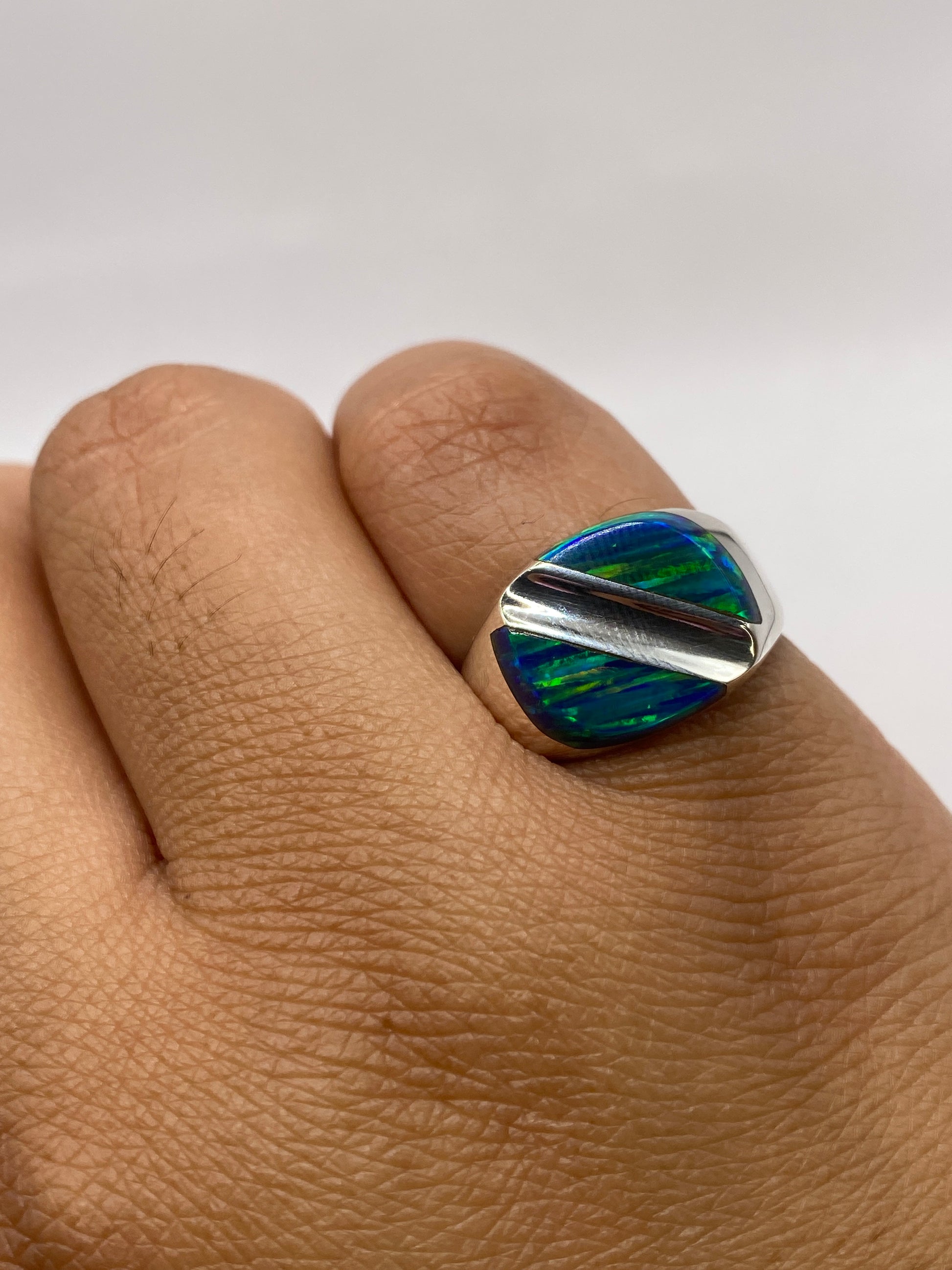 Anillo en dedo mostrando la banda pulida de 8 mm y el brillo del ópalo natural
