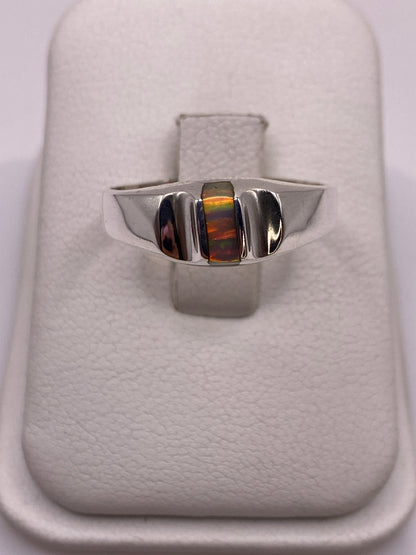 Anillo de plata con ópalo de fuego multicolor en caja de engaste, bandas laterales de plata pulida