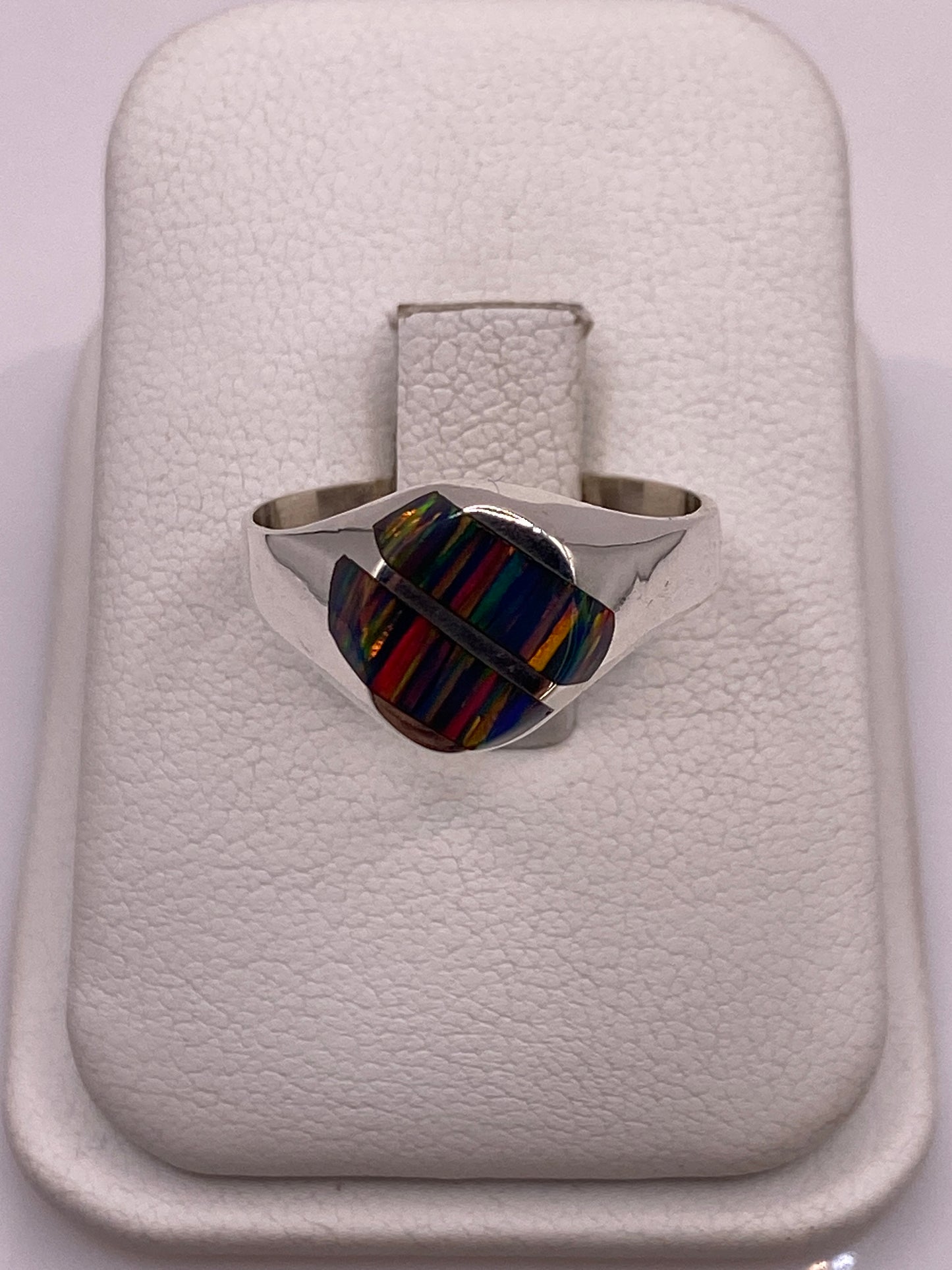 Anillo de plata .950 con ópalo de fuego multicolor en estuche blanco, vista superior mostrando el juego de colores