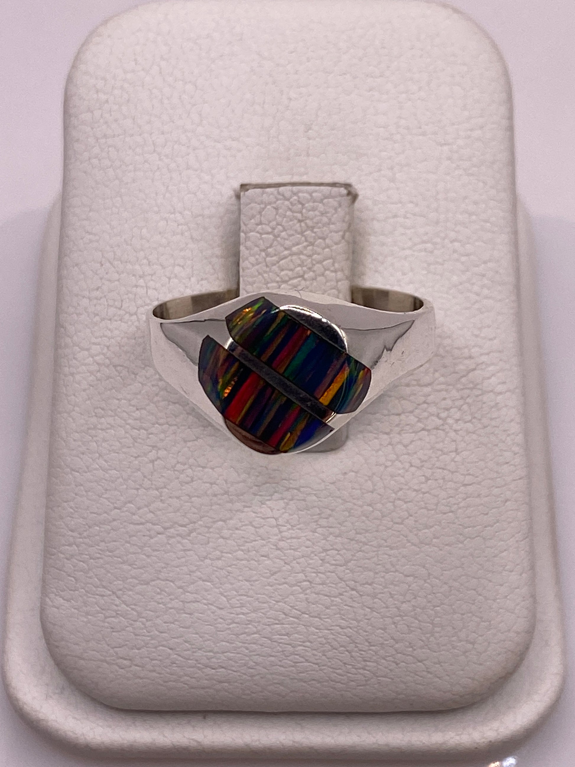 Anillo de plata .950 con ópalo de fuego multicolor en estuche blanco, vista superior mostrando el juego de colores