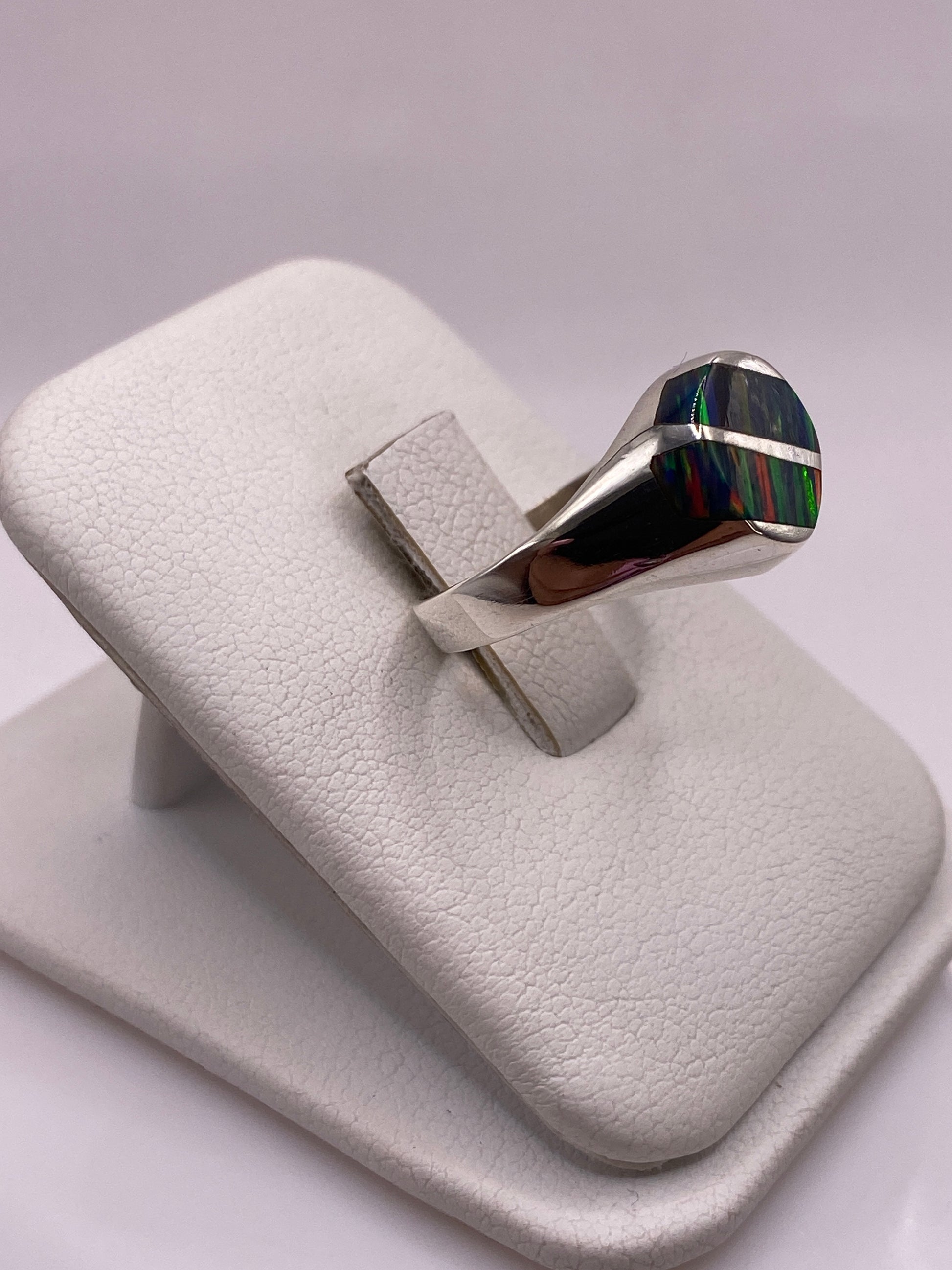 Anillo escultórico de plata .950 ópalo fuego en la mano, detalle lateral de la banda ancha y el ópalo
