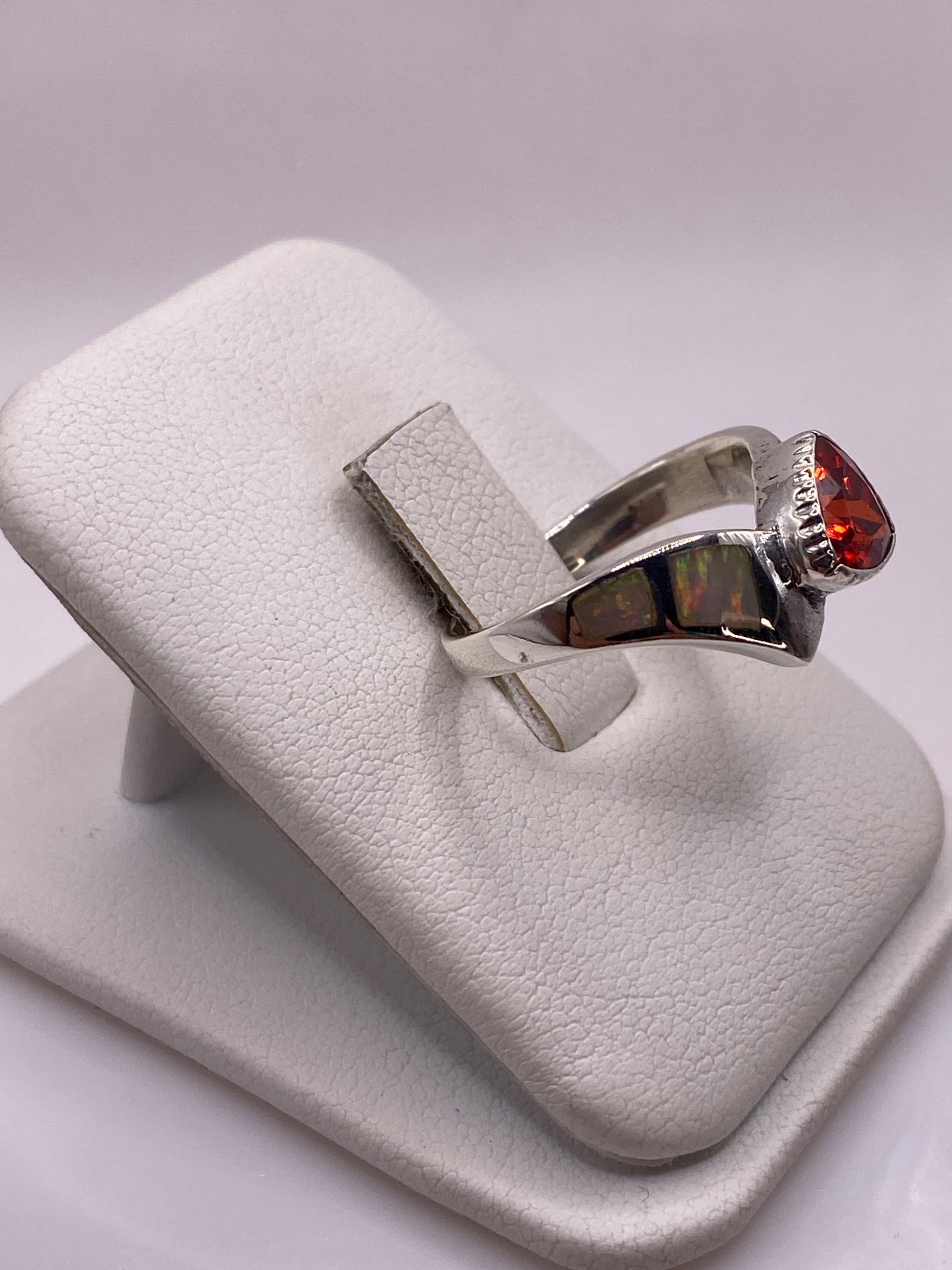Detalle lateral del anillo mostrando el engaste de circonia roja y blanca