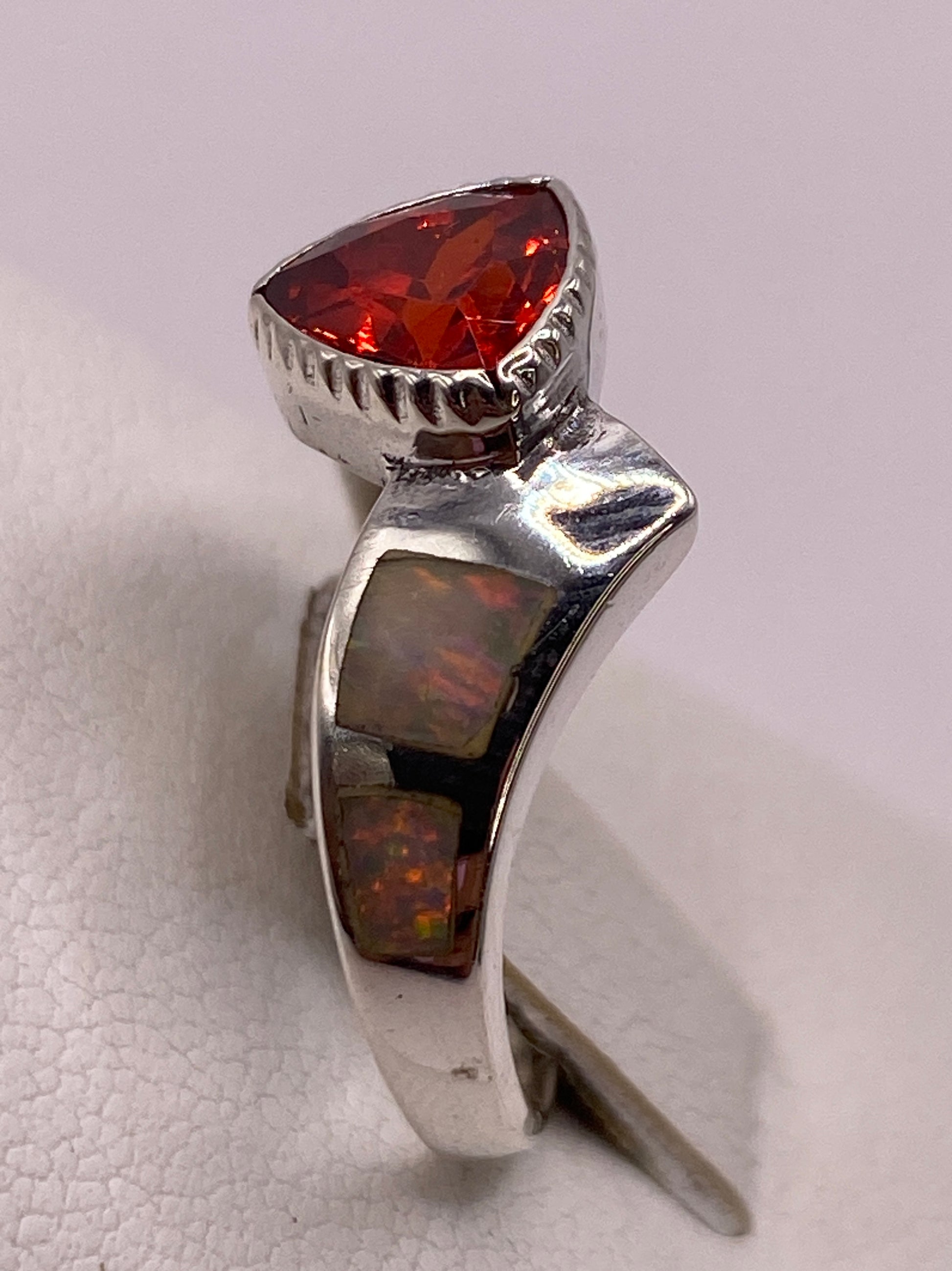 Anillo en la mano mostrando el brillo de la circonia roja con fuego de diamante