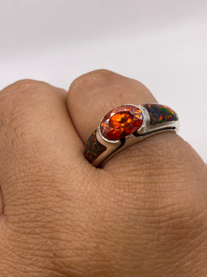 Anillo de ópalo de fuego en dedo, revelando los colores naturales multicolor bajo luz natural