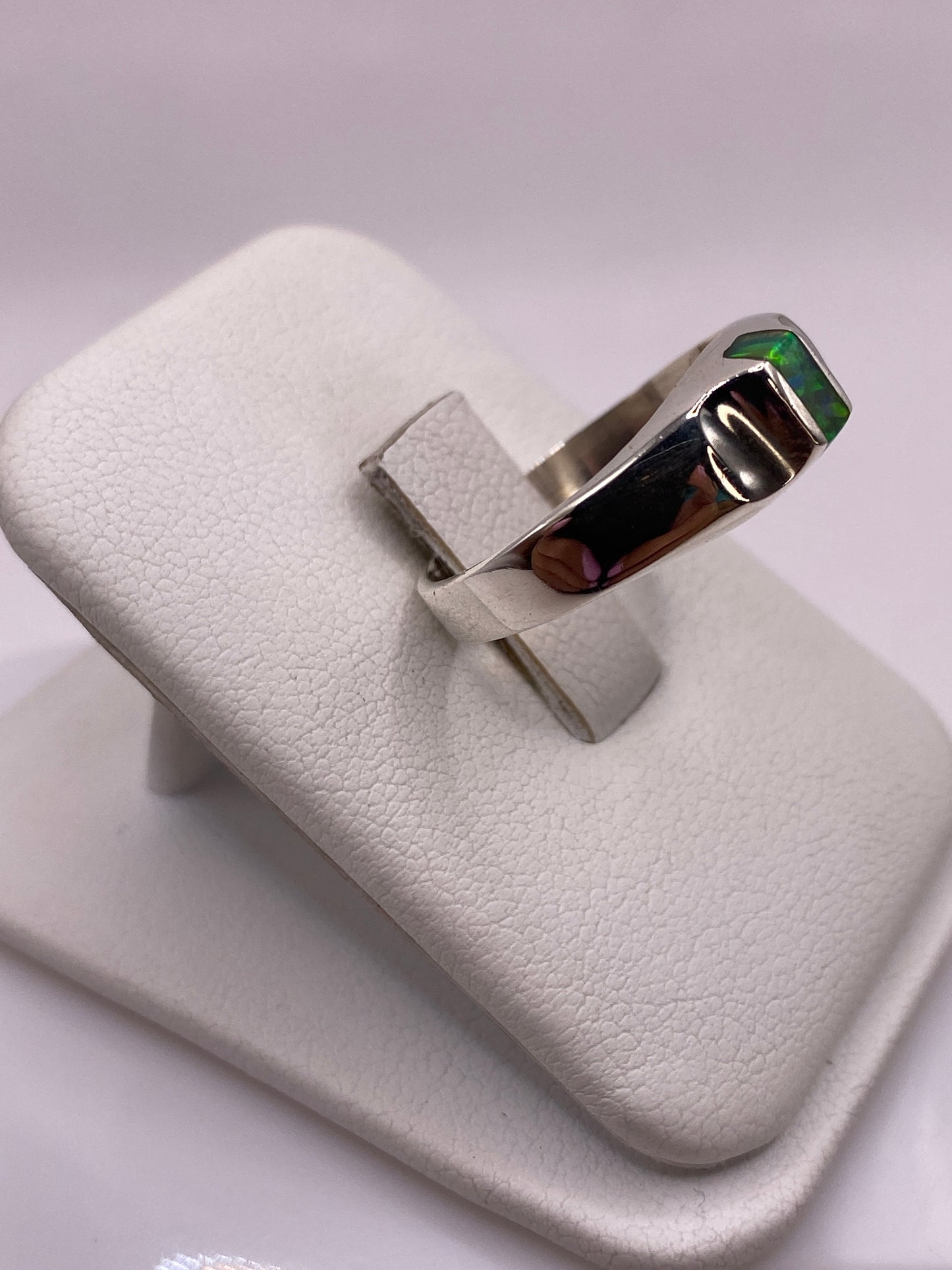 Anillo unisex en plata con ópalo de fuego, detalle lateral mostrando la banda geométrica