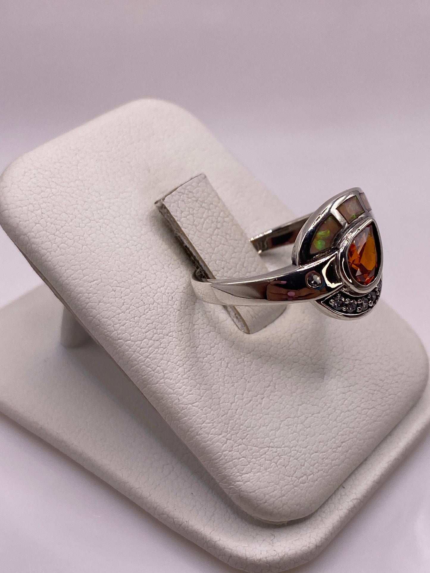 Detalle lateral del anillo geométrico con ópalo natural jugando colores