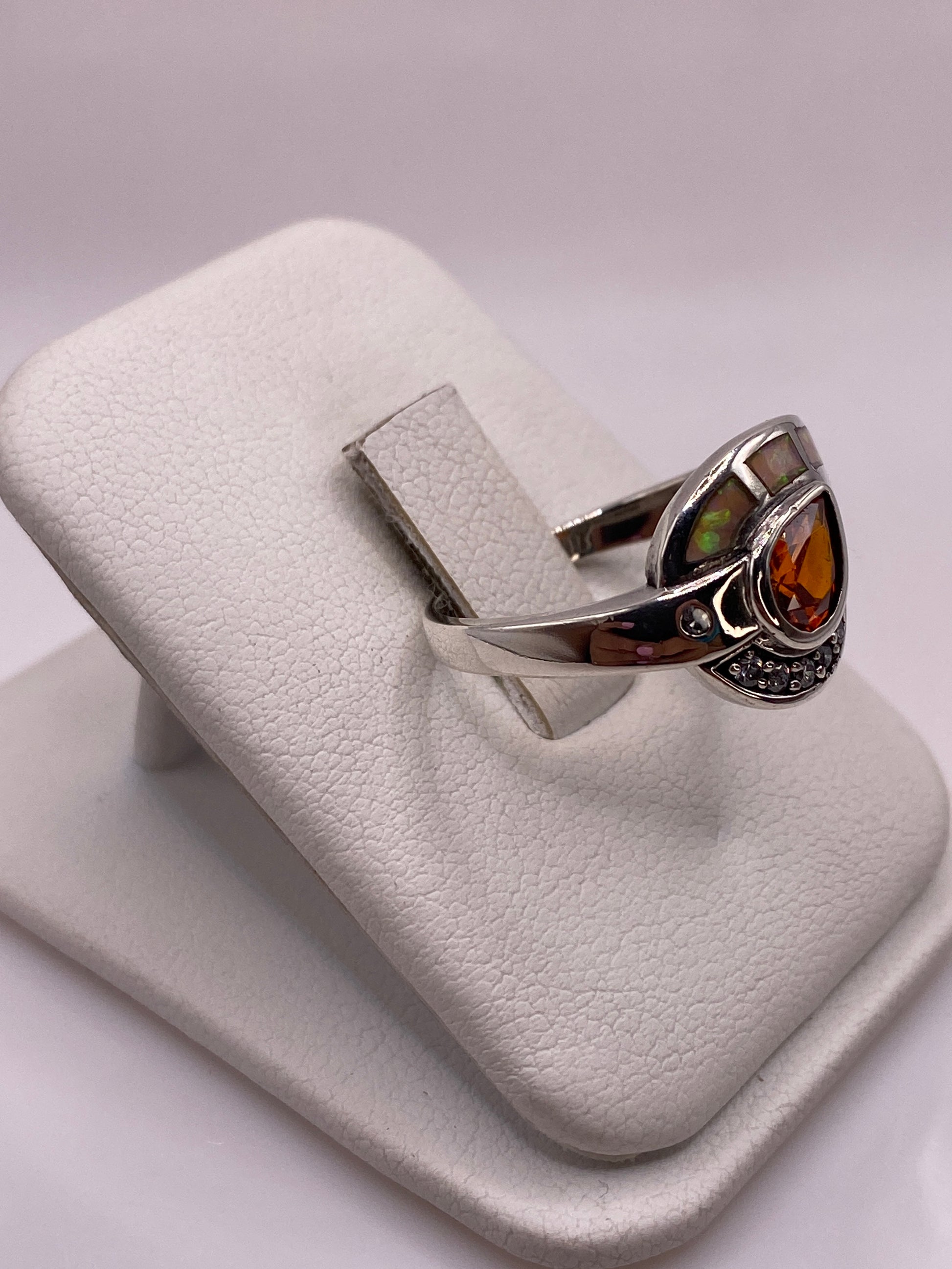 Detalle lateral del anillo geométrico con ópalo natural jugando colores