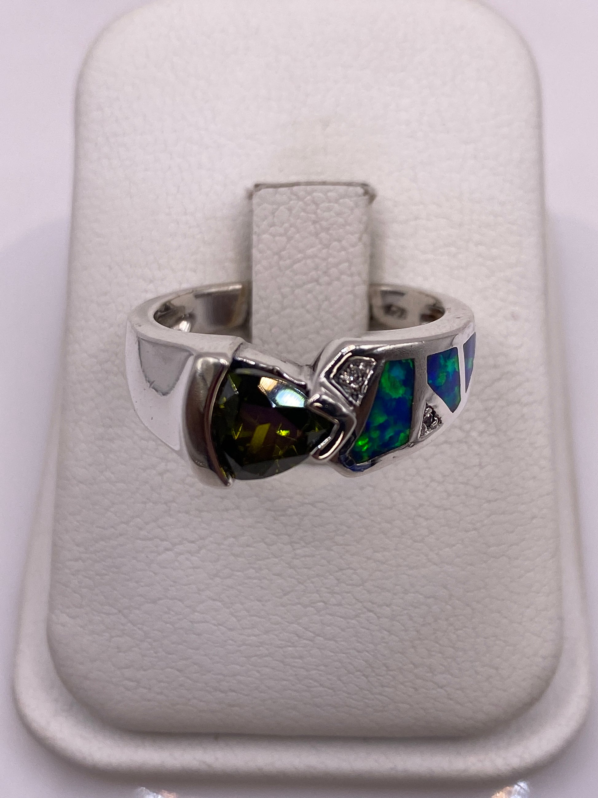 Anillo de plata con ópalo de Fuego verde y reflejos azules en la mano de una mujer
