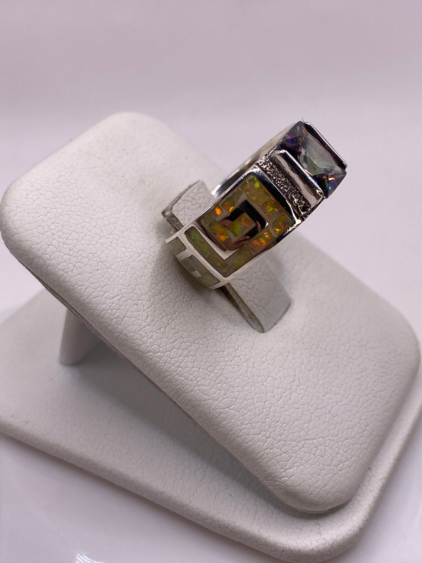 Detalle lateral del anillo mostrando la textura grabada y el brillo del ópalo amarillo
