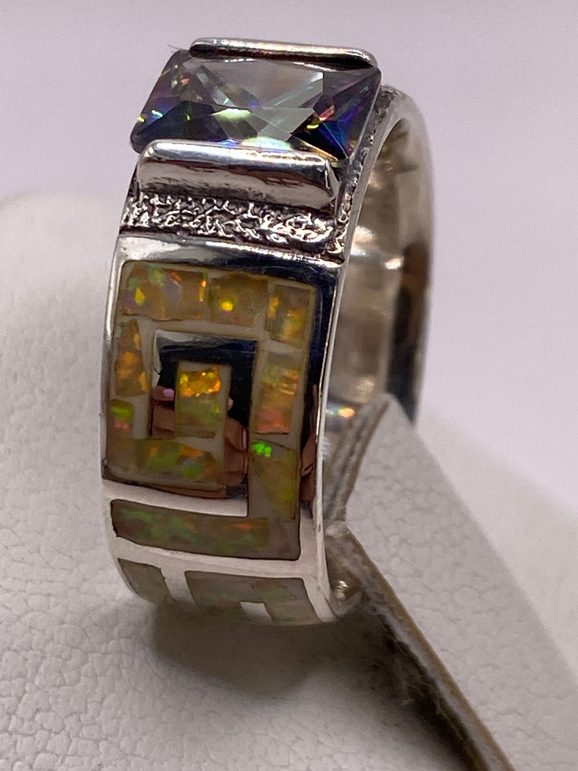 Anillo en la mano con luz natural, el ópalo reflejando fuego amarillo intenso