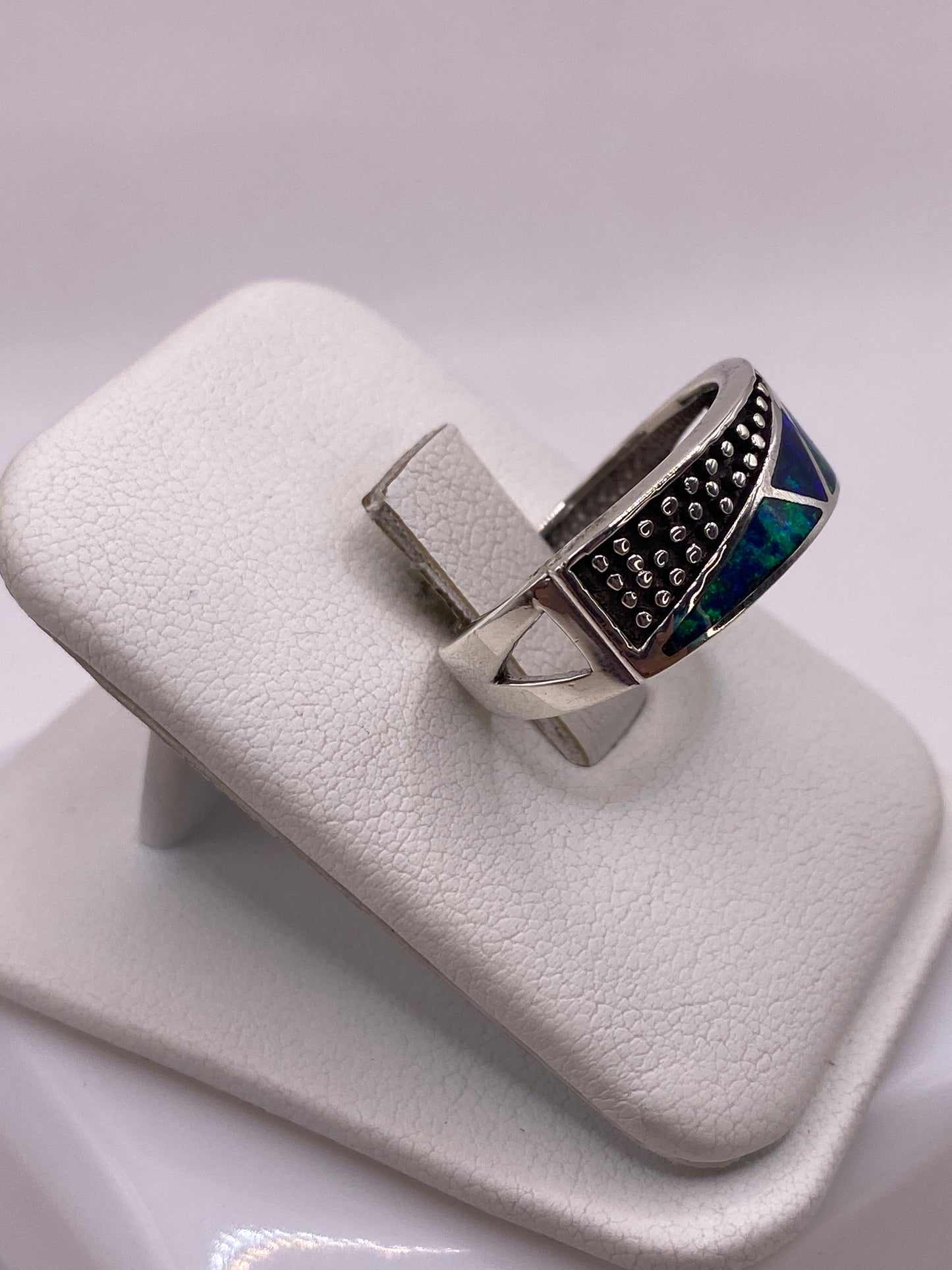 Vista lateral del anillo moderno de plata pura con ópalo de fuego azul