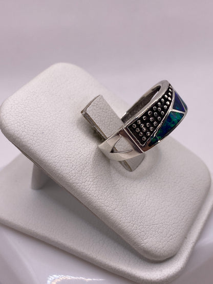 Vista lateral del anillo moderno de plata pura con ópalo de fuego azul