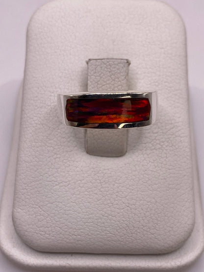 Anillo de plata .925 con ópalo de fuego multicolor en band plana, vista frontal sobre soporte blanco