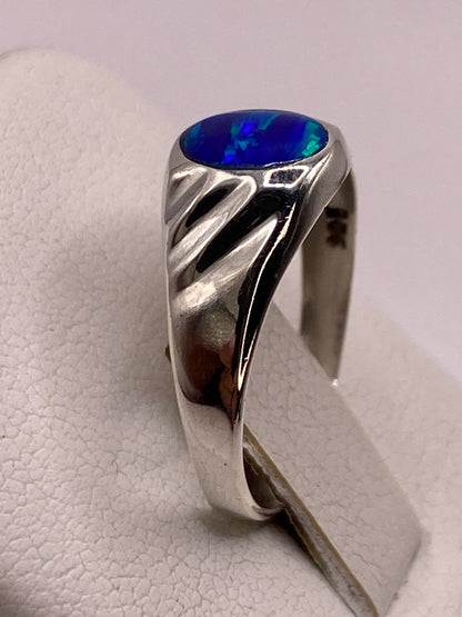 Anillo solitario ópalo de fuego azul visto de perfil, banda pulida de plata .925