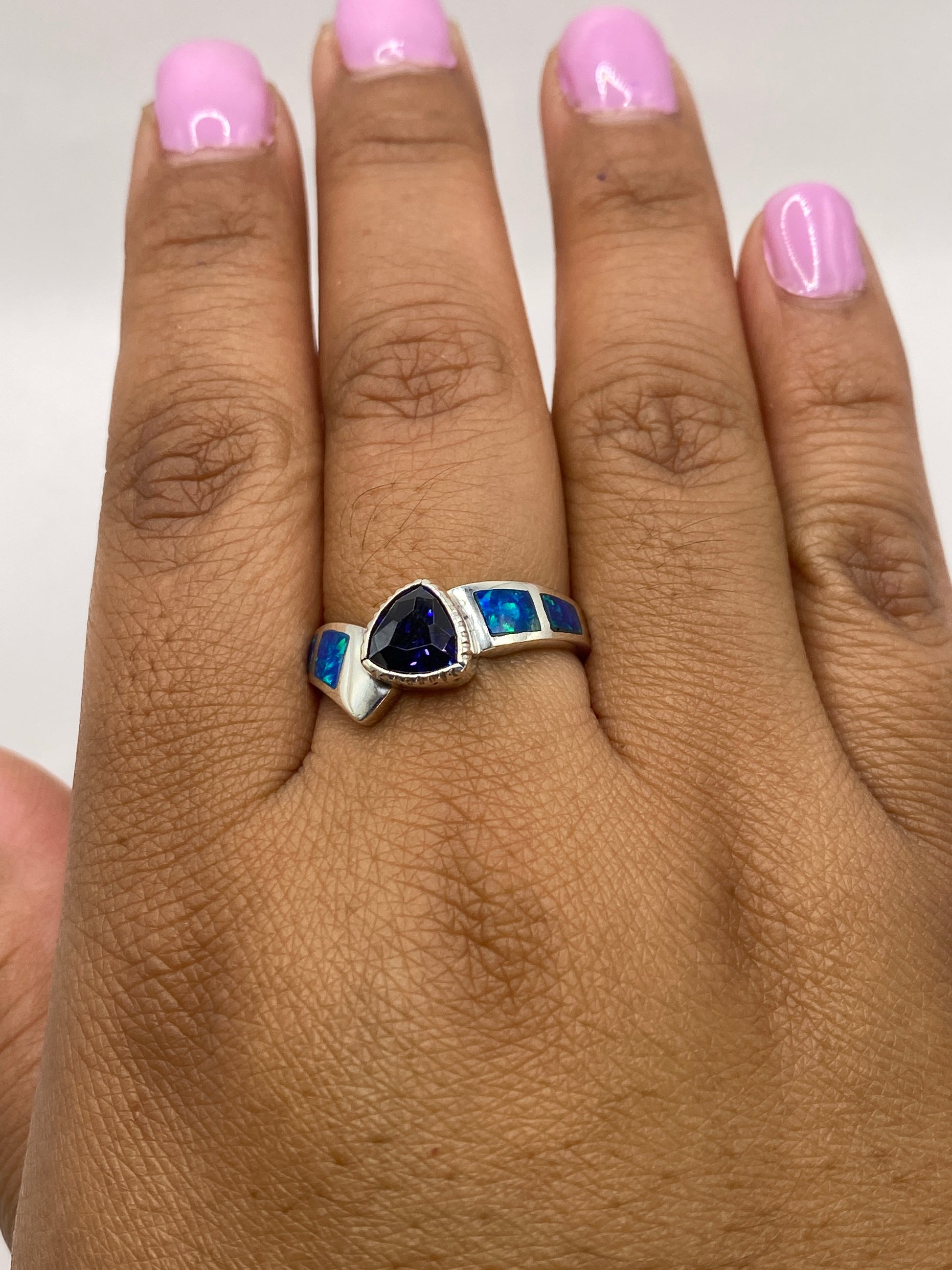 Anillo de ópalo de fuego en mano, capturando el cambio de color natural de la piedra