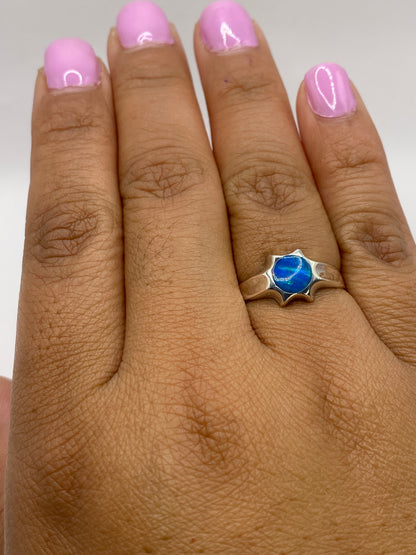 Anillo en dedo mostrando el juego de colores del ópalo bajo luz natural