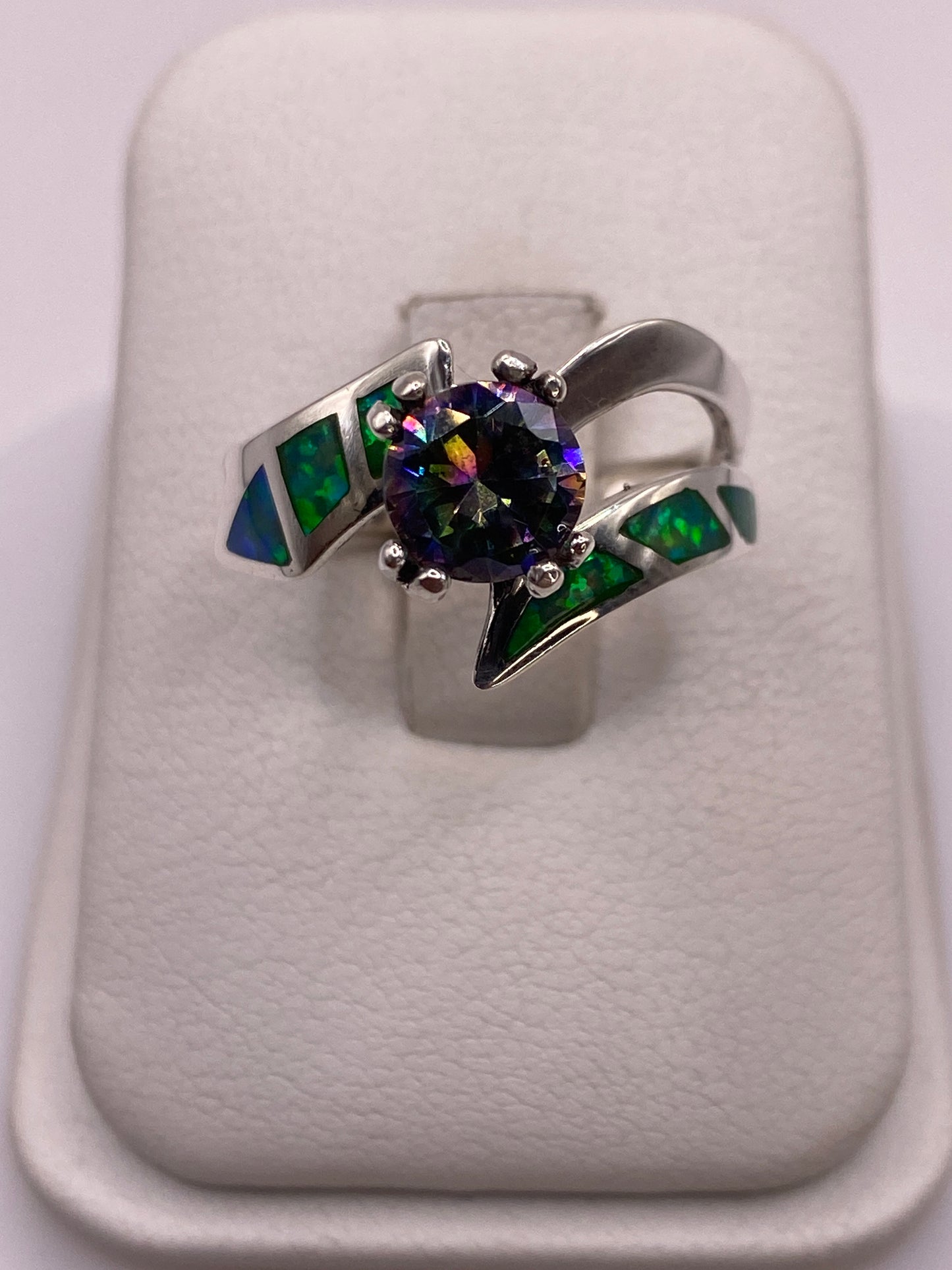 Anillo de plata .950 con ópalo de fuego verde y engastes laterales verdes en la mano