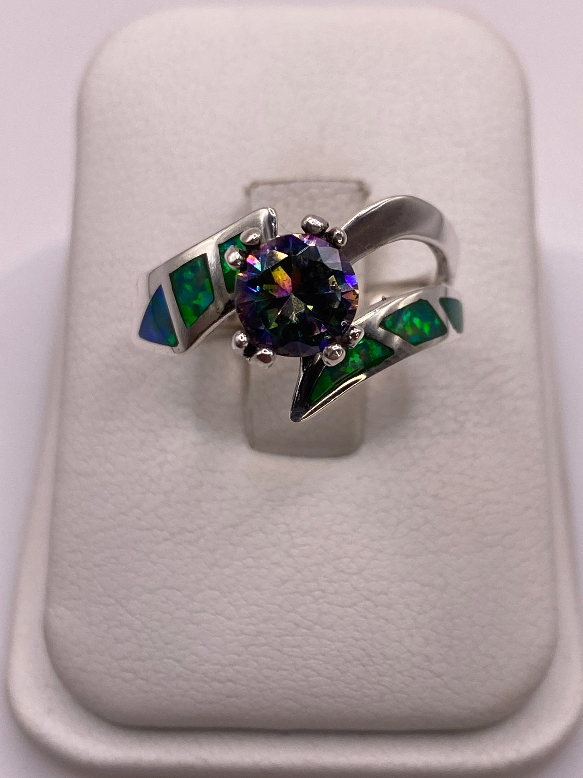 Anillo de plata .950 con ópalo de fuego verde y engastes laterales verdes en la mano