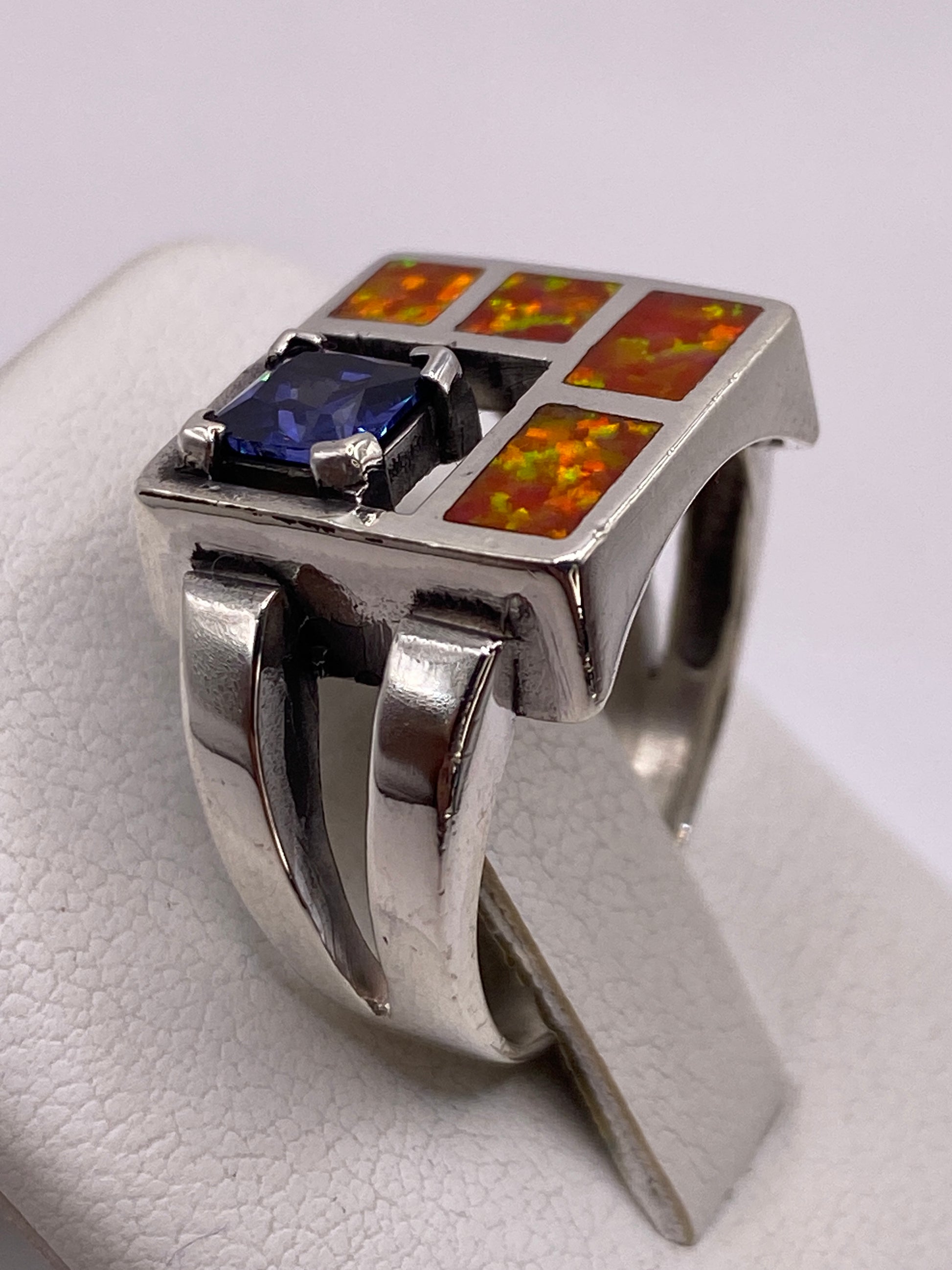 Anillo unisex con ópalo naranja en la mano mostrando el juego de colores natural