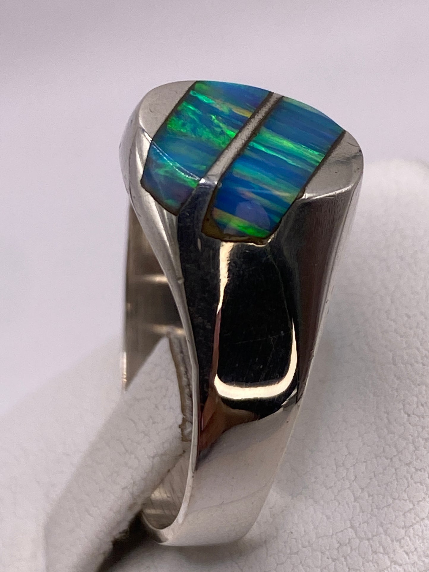Detalle del Ópalo de Fuego con reflejos verdes y azules en la mano