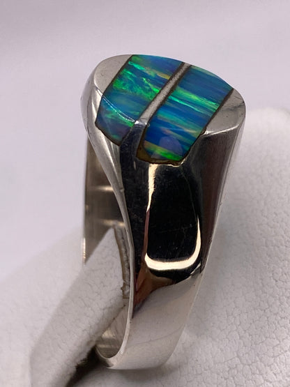 Detalle del Ópalo de Fuego con reflejos verdes y azules en la mano