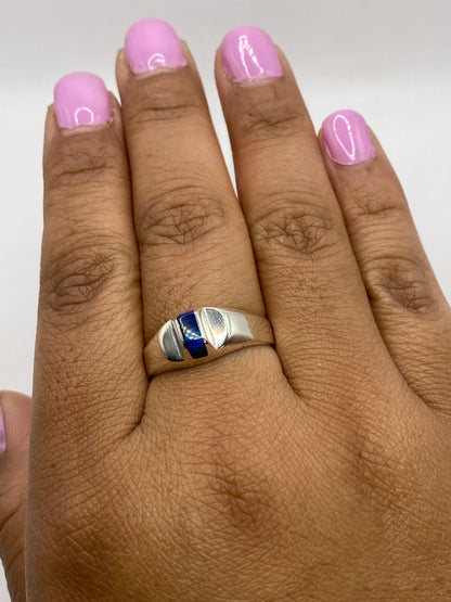 Anillo en la mano mostrando brillo y profundidad del ópalo, con sello 950 visible