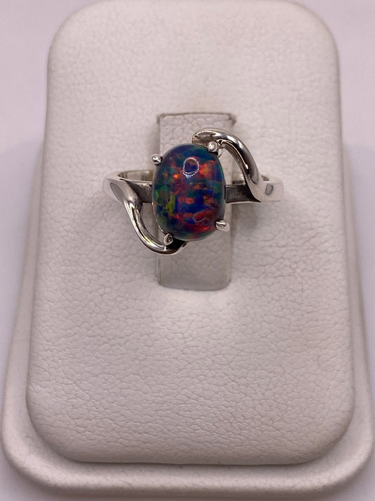 Anillo solitario de ópalo de fuego natural con engaste en plata .950, sobre peana blanca