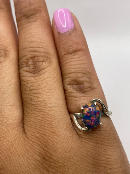 Anillo sobre dedo mostrando el brillo multicolor del ópalo bajo luz natural