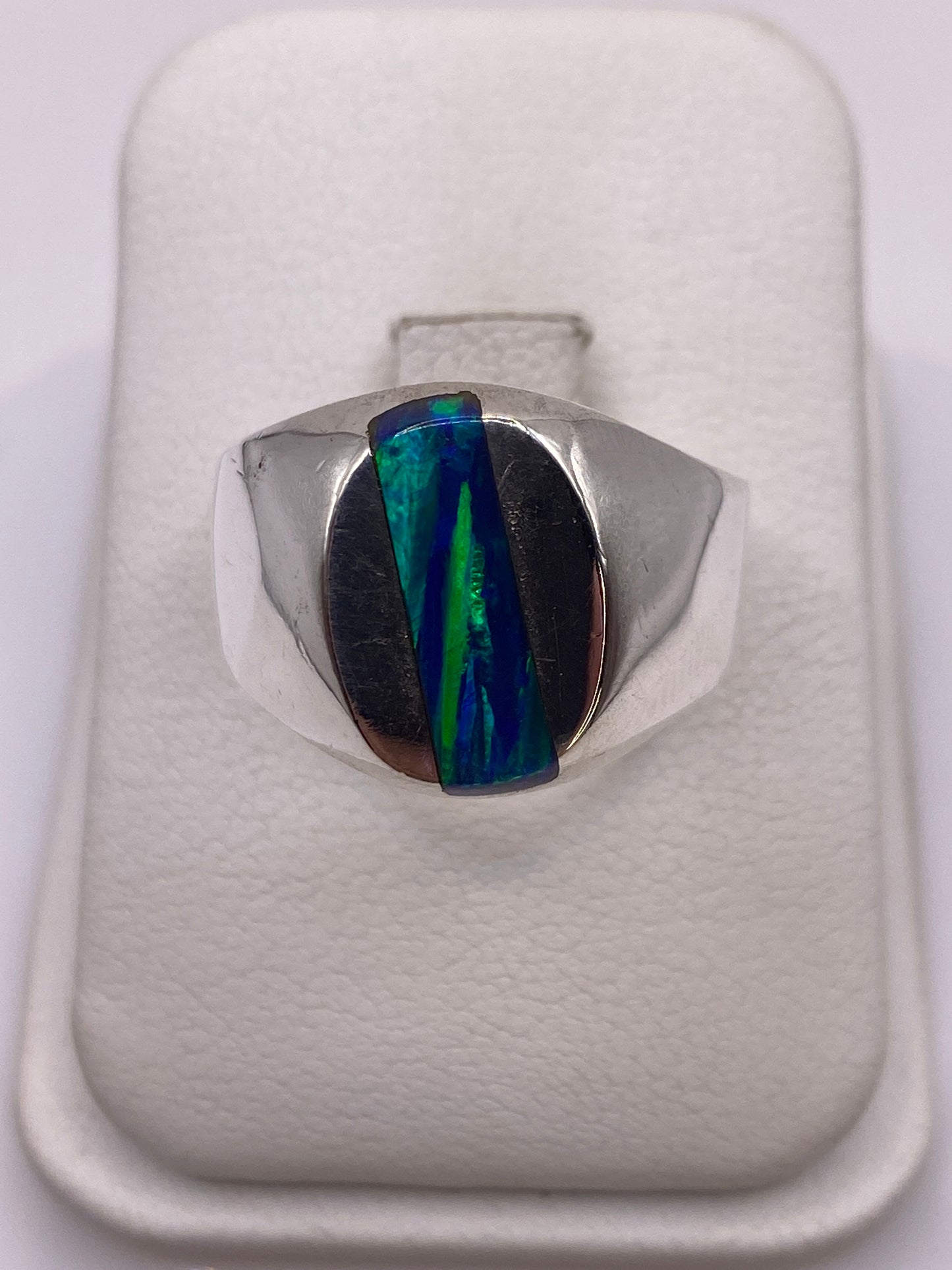 Anillo de plata .925 con ópalo de fuego multicolor en la mano de un hombre