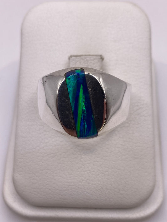 Anillo de plata .925 con ópalo de fuego multicolor en la mano de un hombre