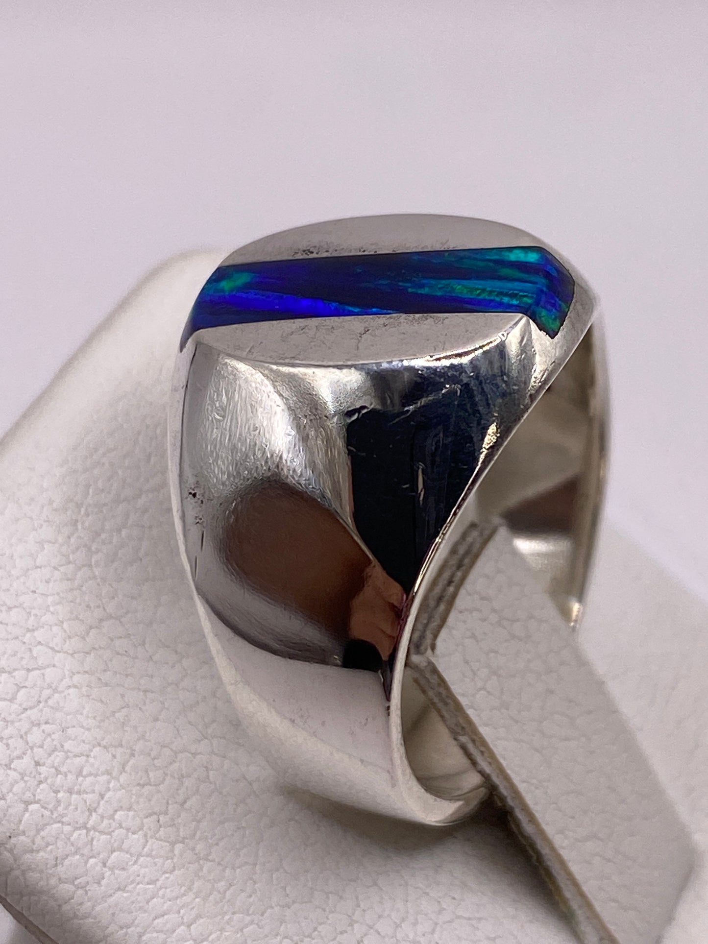 Detalle lateral del anillo en plata pulida con banda ancha y piedra engastada