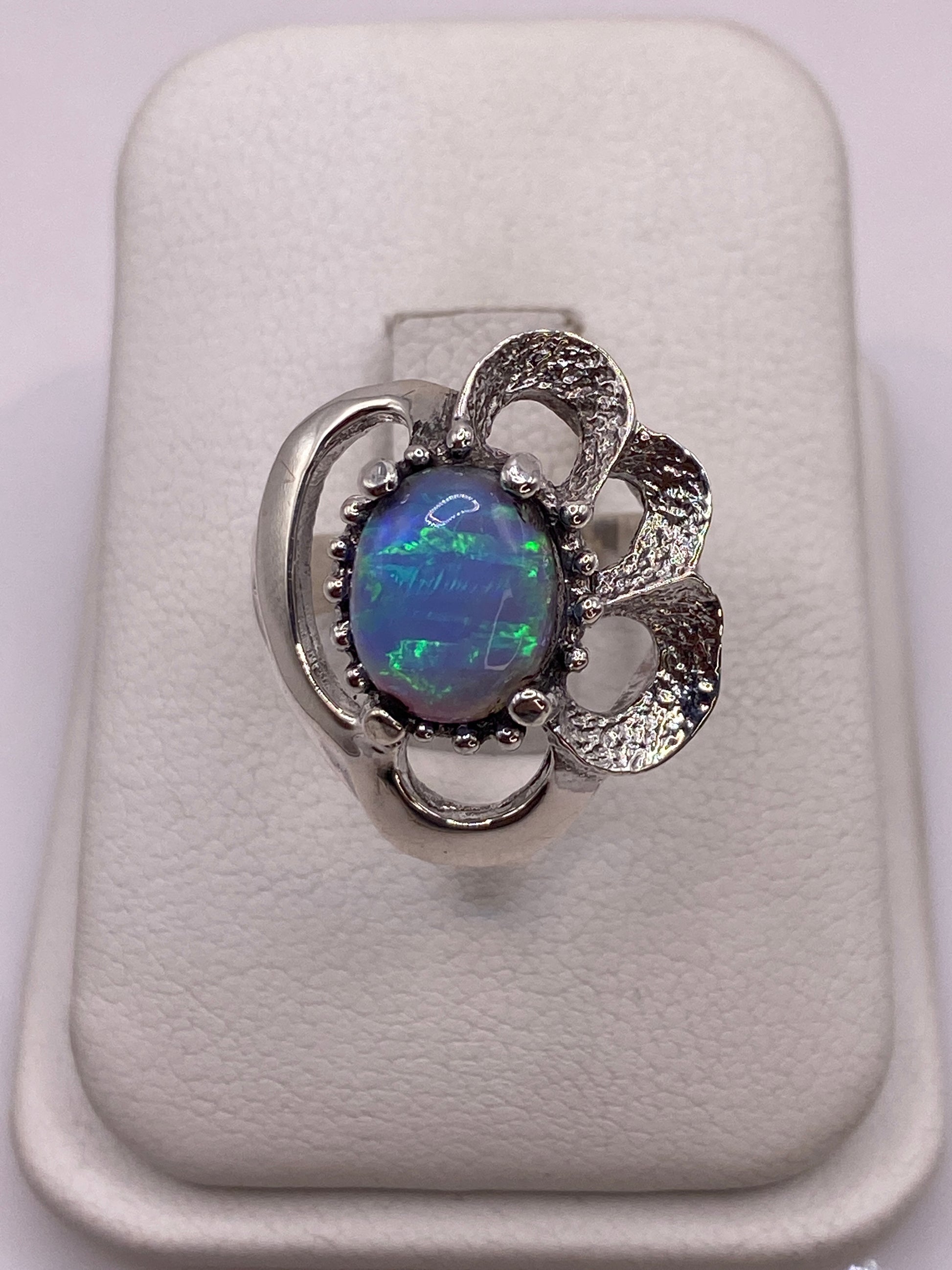 Anillo de plata con ópalo de fuego azul cielo en pétalo envolvente, vista frontal