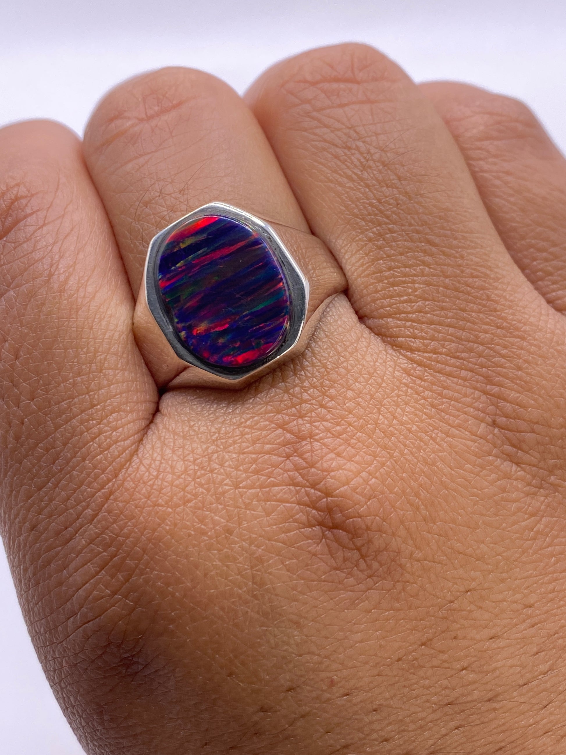 Anillo en la mano mostrando el peso y la presencia de la plata .950 y el fuego del ópalo