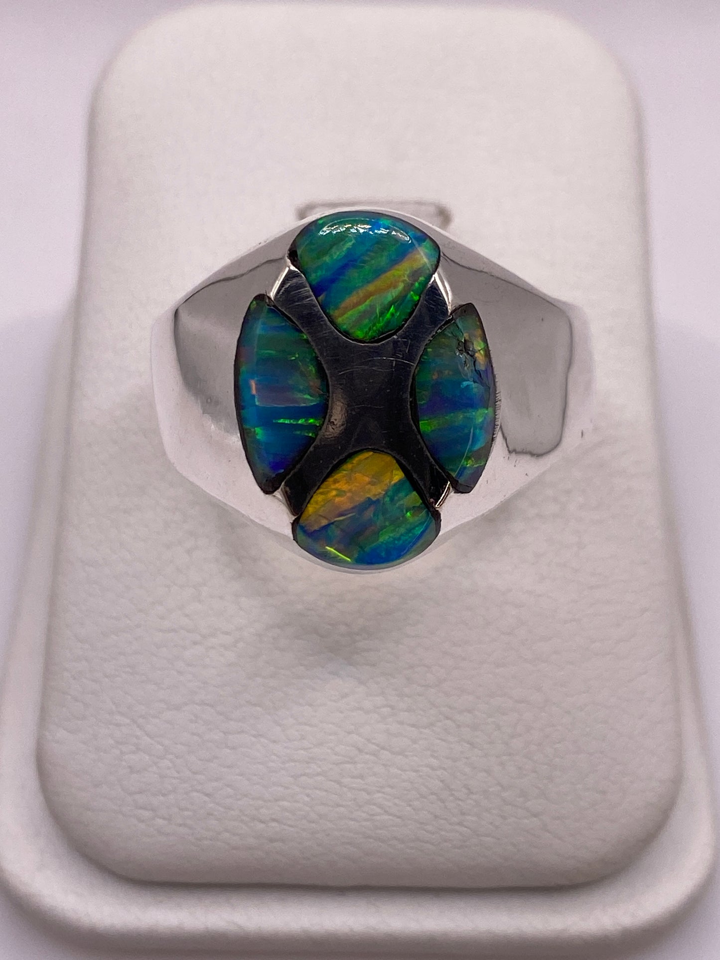 Anillo de plata con ópalo de fuego multicolor mostrando verde, azul y naranja
