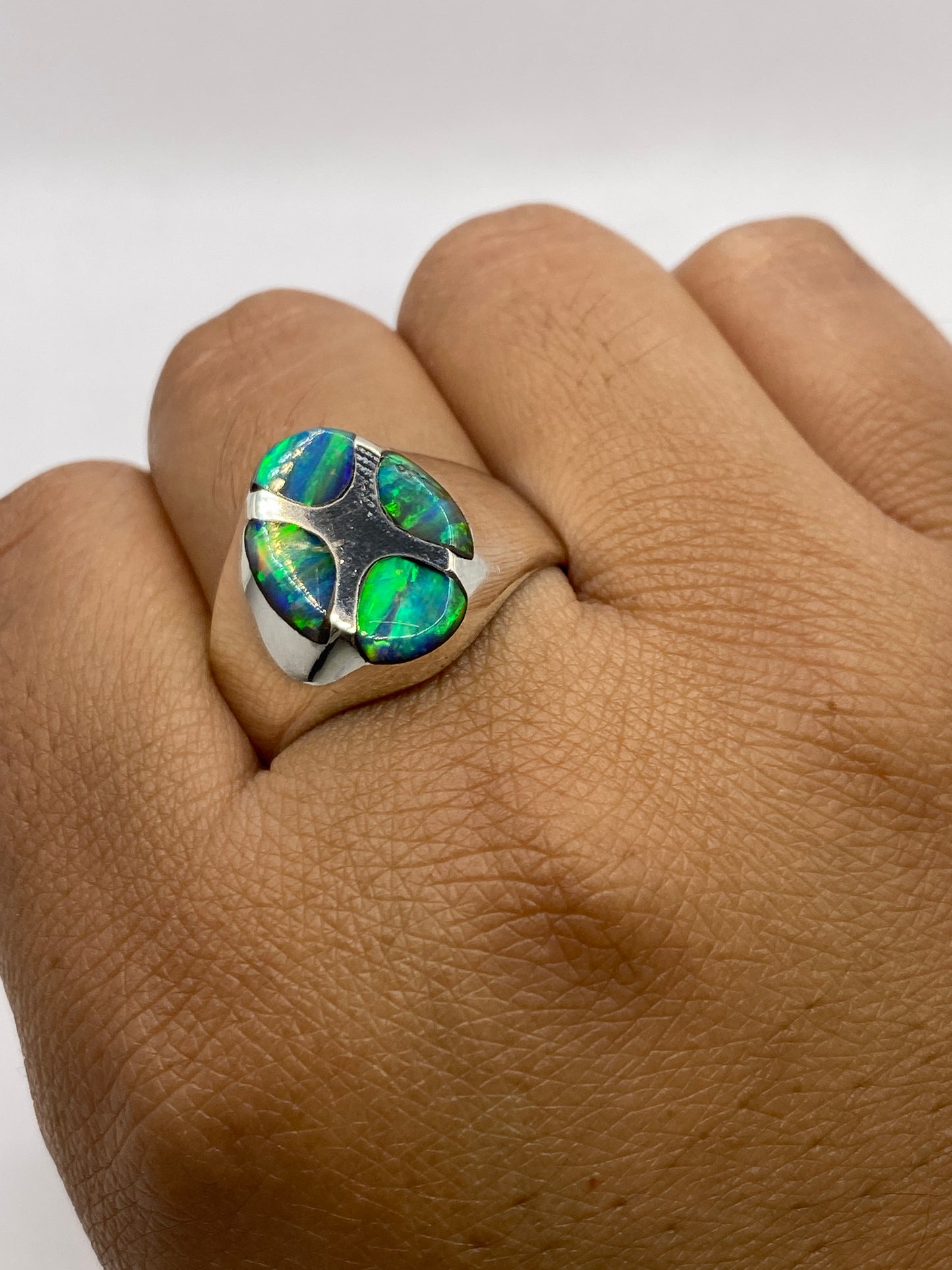 Anillo ópalo de fuego en dedo mostrando el juego de colores completo