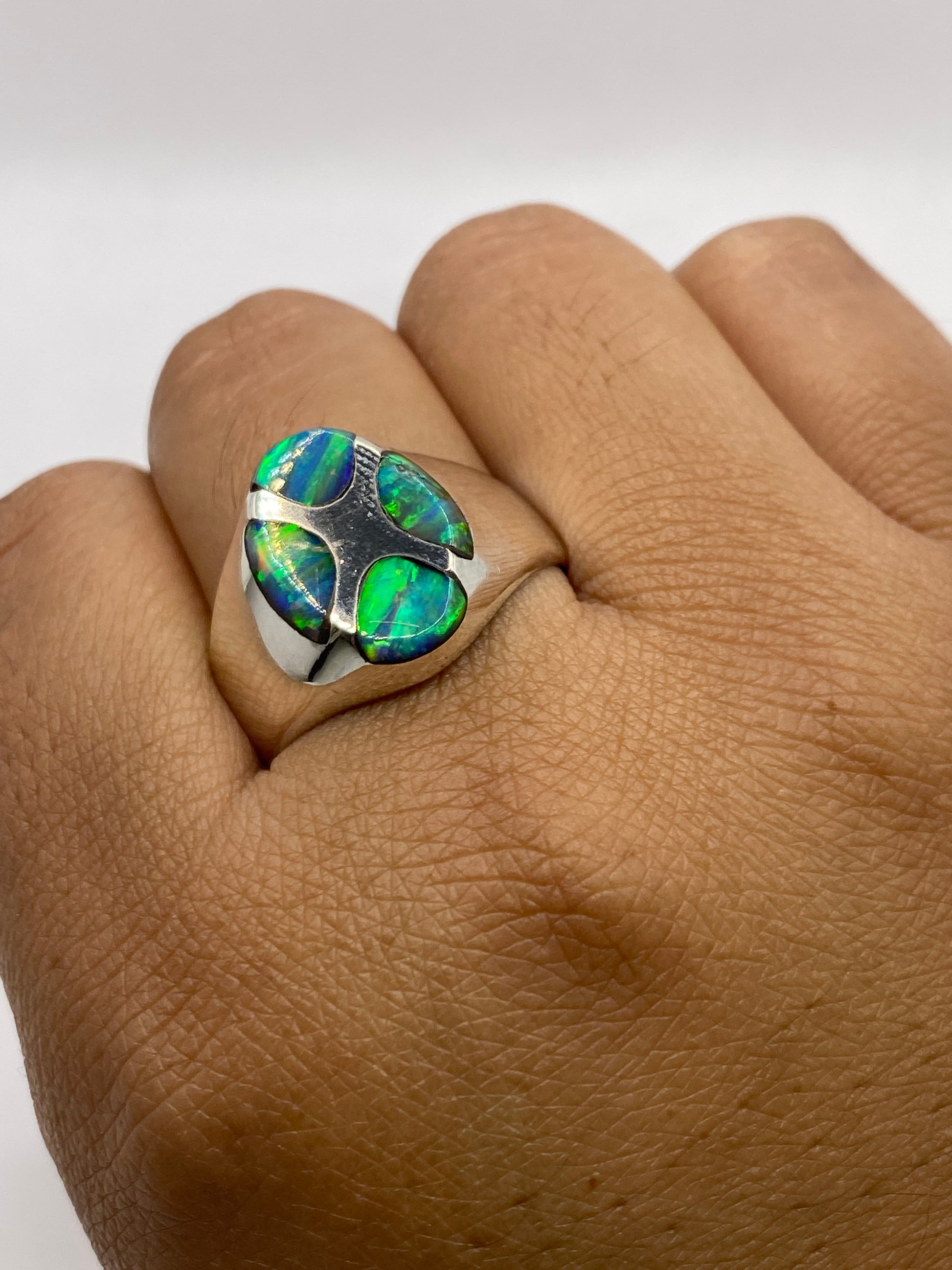 Anillo ópalo de fuego en dedo mostrando el juego de colores completo