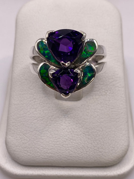 Anillo de plata con doble corazón de ópalo de fuego verde iridiscente sobre dedo de mujer