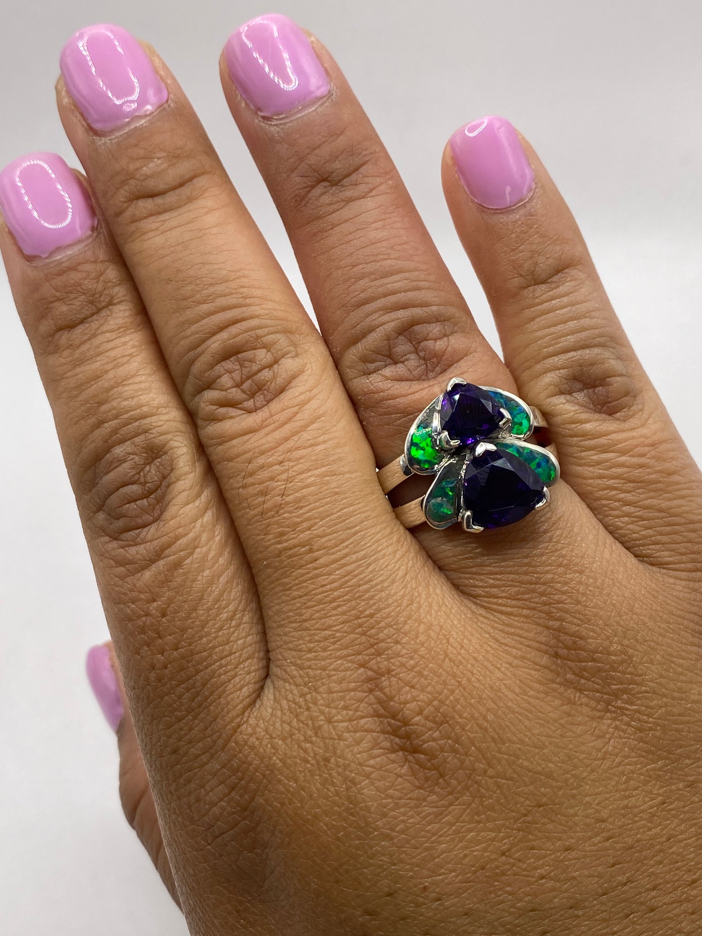 Anillo solitario sobre mesa blanca revelando el sello 925 y el fuego mineral del ópalo