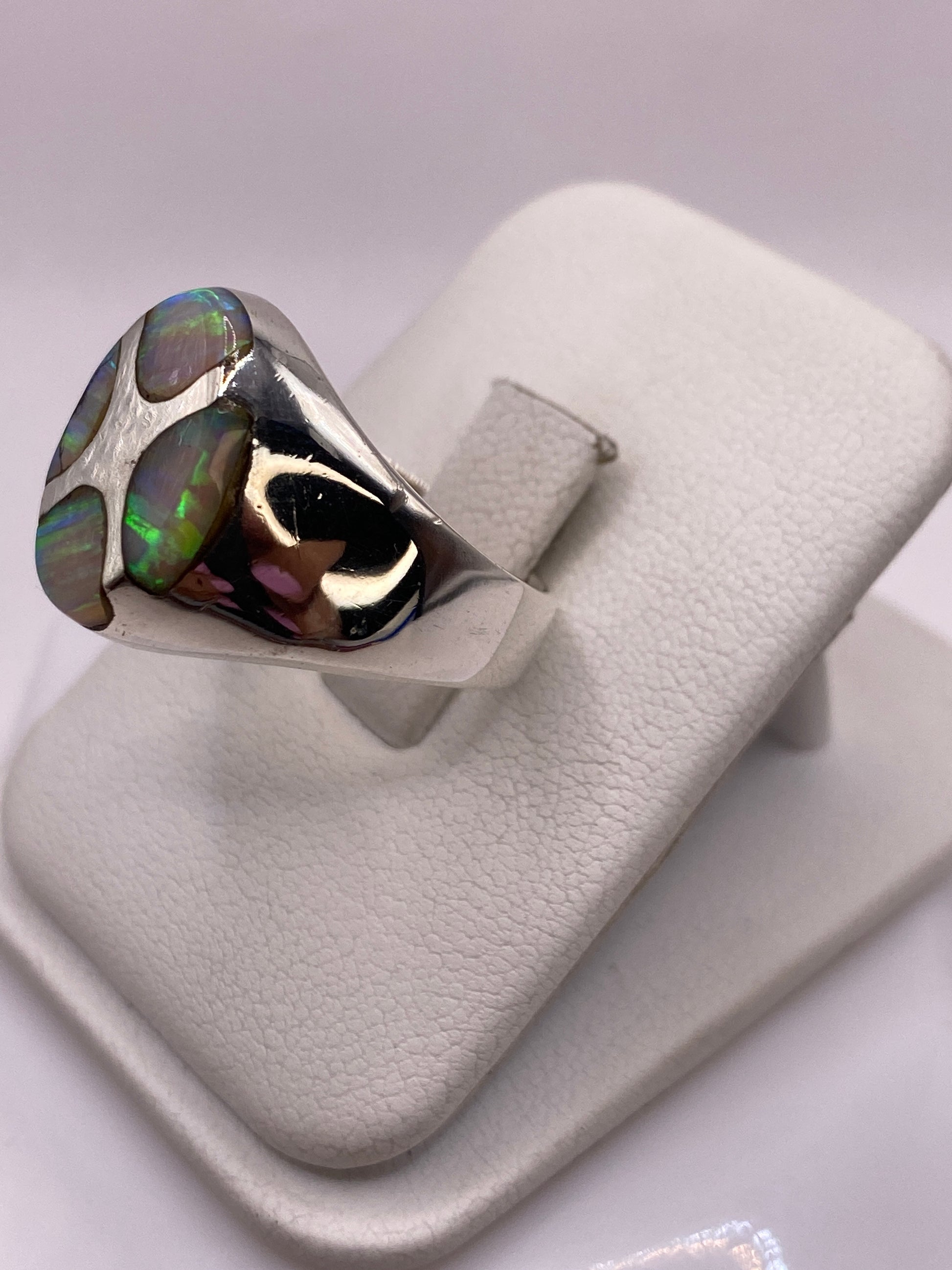 Anillo escultural de ópalo de fuego visto de perfil en la mano, destacando el diseño de presencia