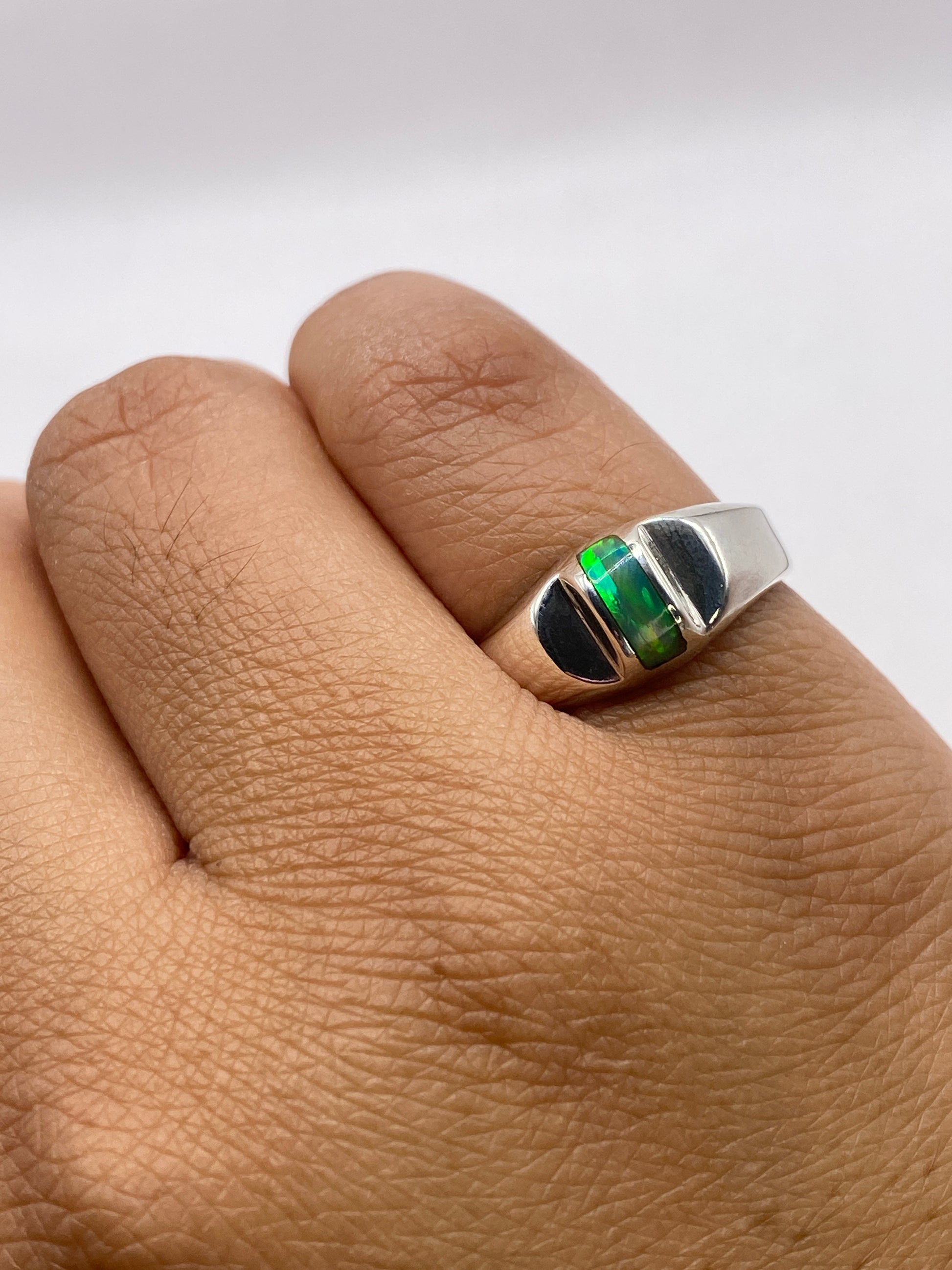 Anillo puesto en la mano mostrando el fuego natural de la piedra con luz natural