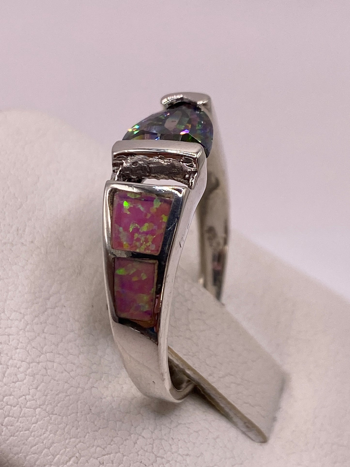 Anillo solitario ópalo fuego rosa en dedo con uñas rosa pálido