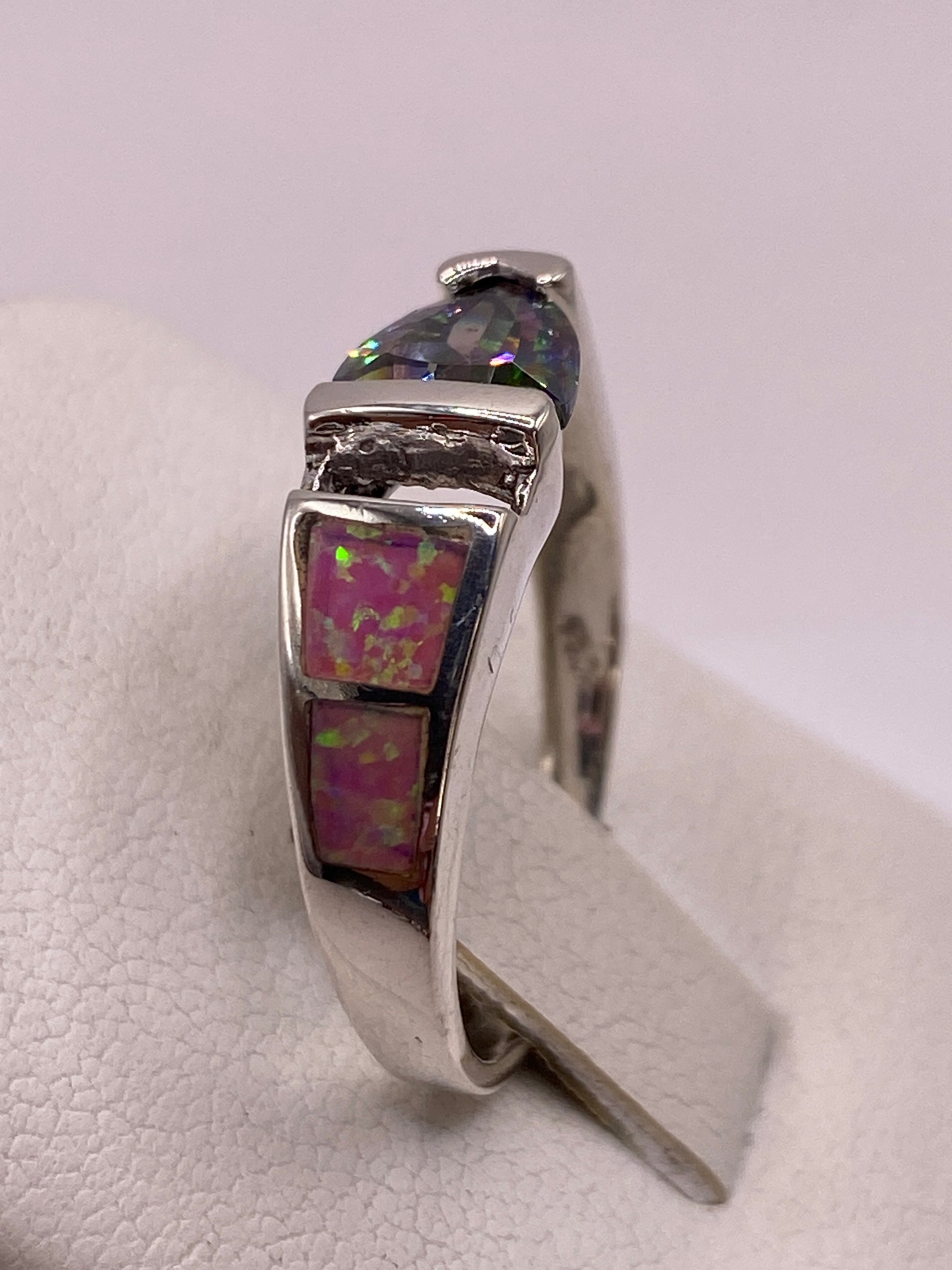 Anillo solitario ópalo fuego rosa en dedo con uñas rosa pálido