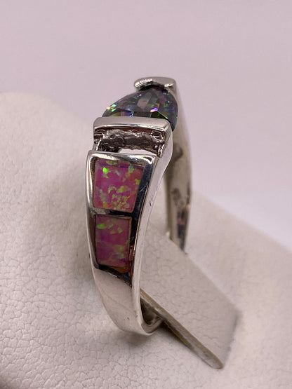 Anillo solitario ópalo fuego rosa en dedo con uñas rosa pálido