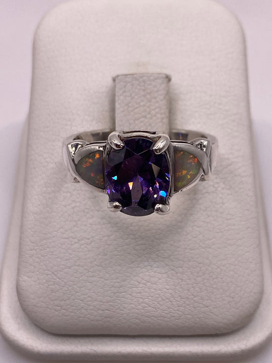 Anillo de plata con ópalo de fuego multicolor mostrando tonos naranja, rojo y verde sobre fondo blanco